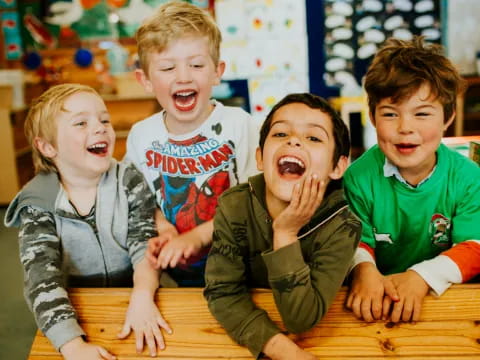 a group of kids sitting at a table with their mouths open