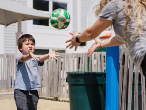 a person and a child playing with a ball