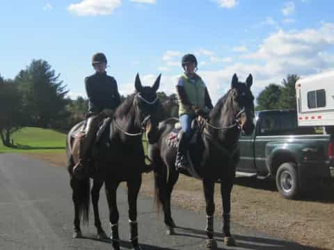 a couple of people ride on horses