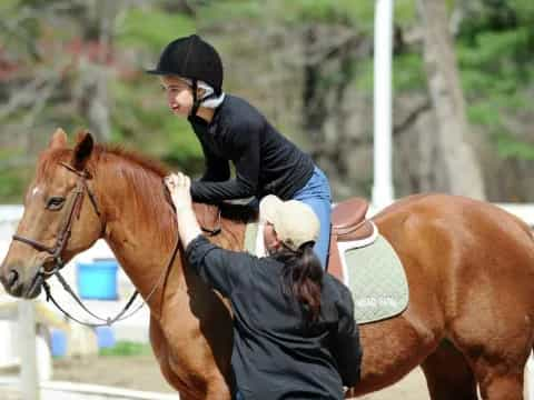 a woman riding a horse with a man on the back