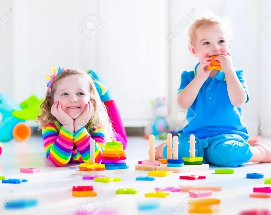 a couple of children sitting at a table with toys