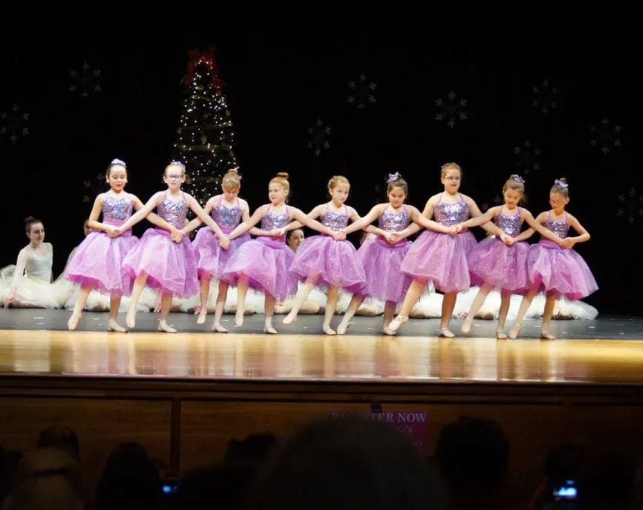 a group of women in dresses on a stage