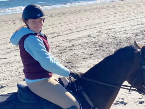 a girl riding a horse on the beach