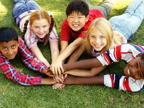 a group of children lying on the grass