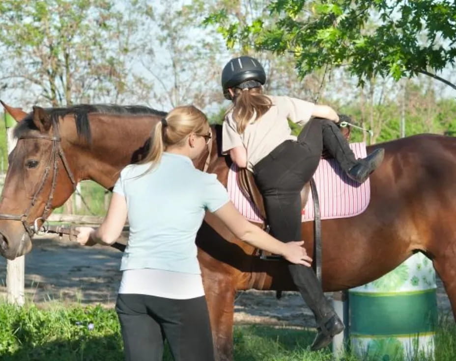 a woman riding a horse with another woman on the back