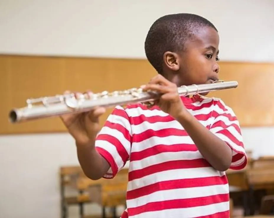 a young boy playing a flute