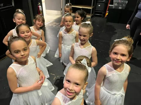 a group of children in white dresses