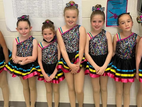 a group of girls in colorful dresses