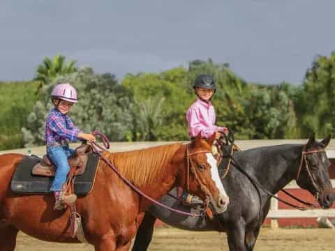 a couple of girls riding horses