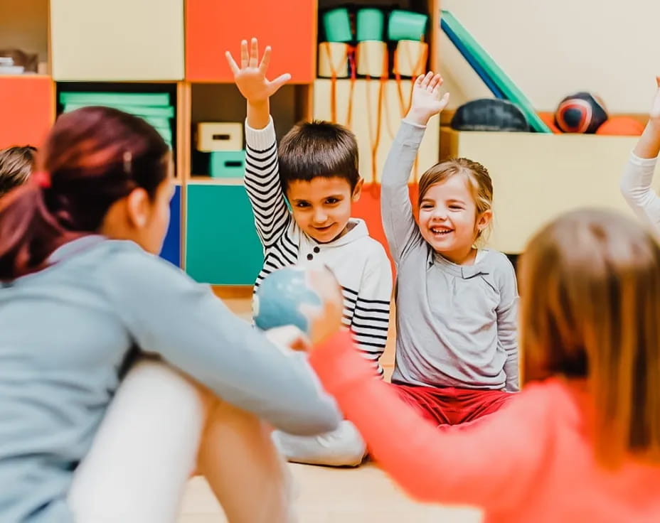 a group of children raising their hands