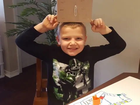 a boy holding a cardboard box