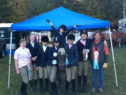 a group of people posing for a photo under a tent