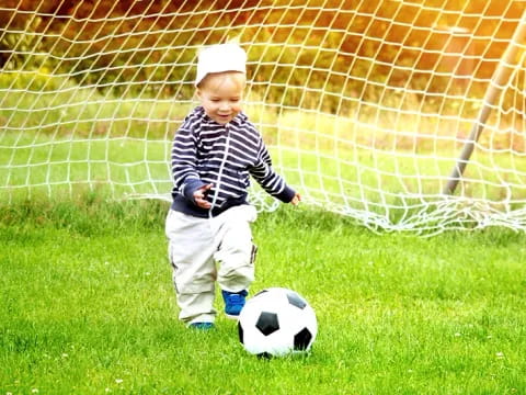 a baby playing with a football ball