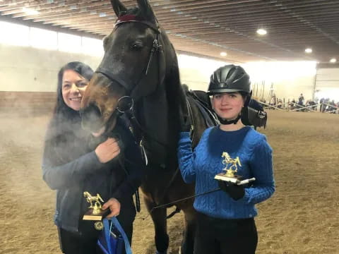 a woman and a man posing with a horse