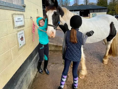 a couple of girls walking a horse