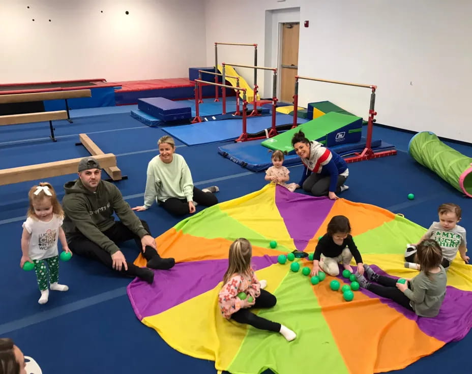 a group of people playing on a colorful mat in a room