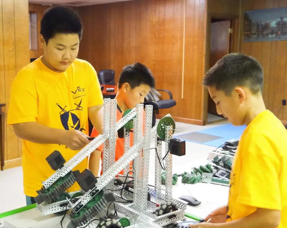 a group of boys working on a machine