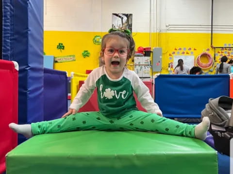 a girl sitting on a green slide