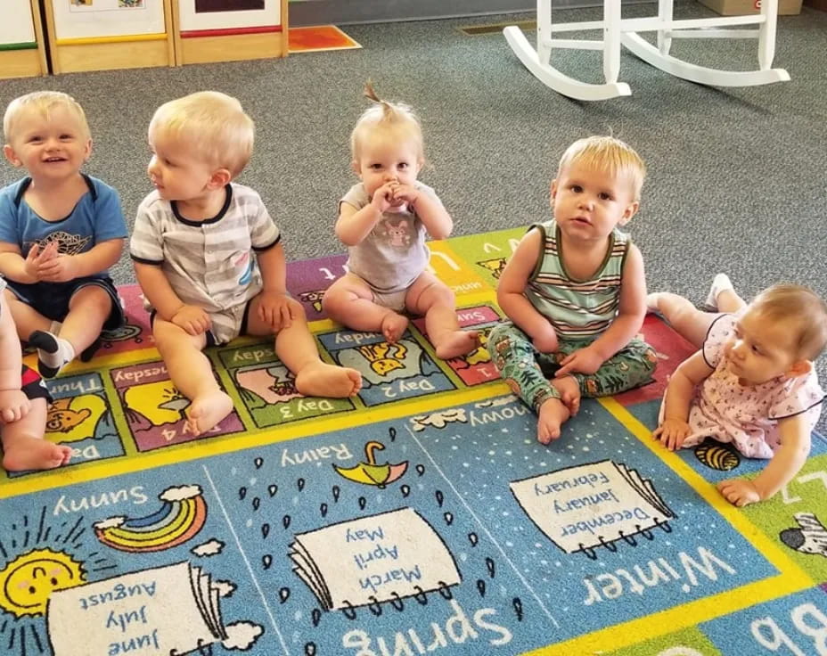 a group of children sitting on the floor playing with puzzle pieces