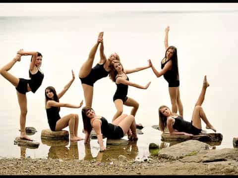 a group of women jumping in the air on a beach