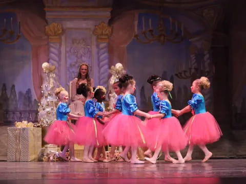 a group of children in dresses on a stage