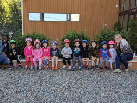 a group of children sitting on a bench in front of a building