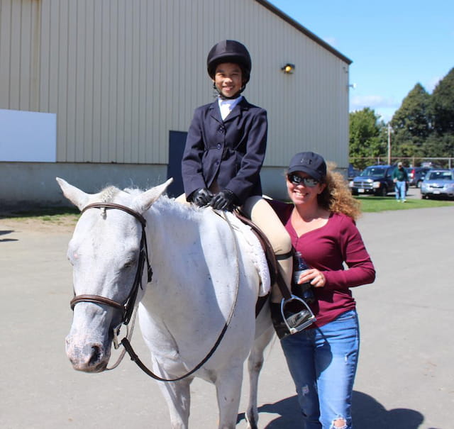 a man on a horse with a woman standing next to him