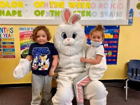 a boy and a girl posing with a person in a rabbit garment