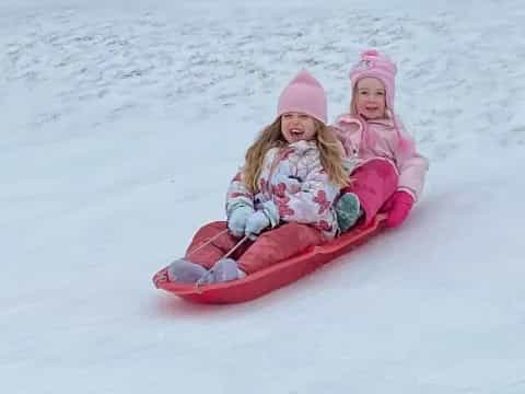 two girls in a sled in the snow