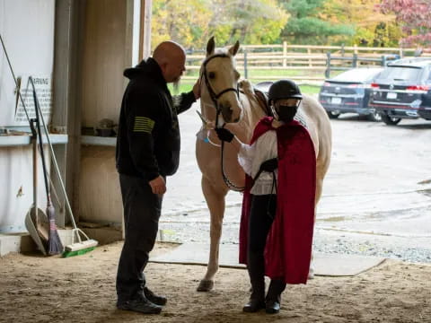 a man and a woman standing next to a horse