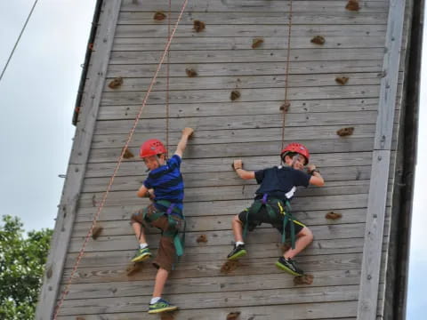 two kids climbing a wooden structure