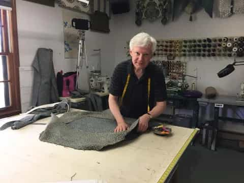 a man standing next to a large fish on a table