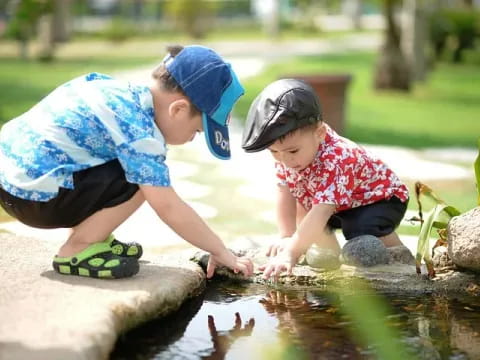 a person and a child playing in a pond