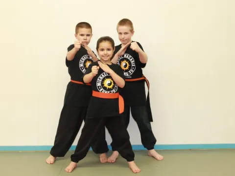 a group of boys in martial arts uniforms posing for a picture