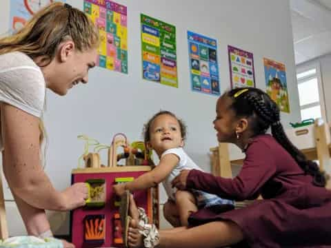 a person and a child playing with toys in a room with posters