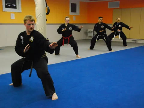 a group of people in martial arts uniforms in a room