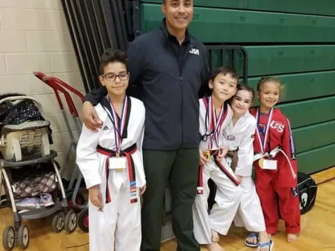 a person and a group of kids wearing medals and posing for a photo