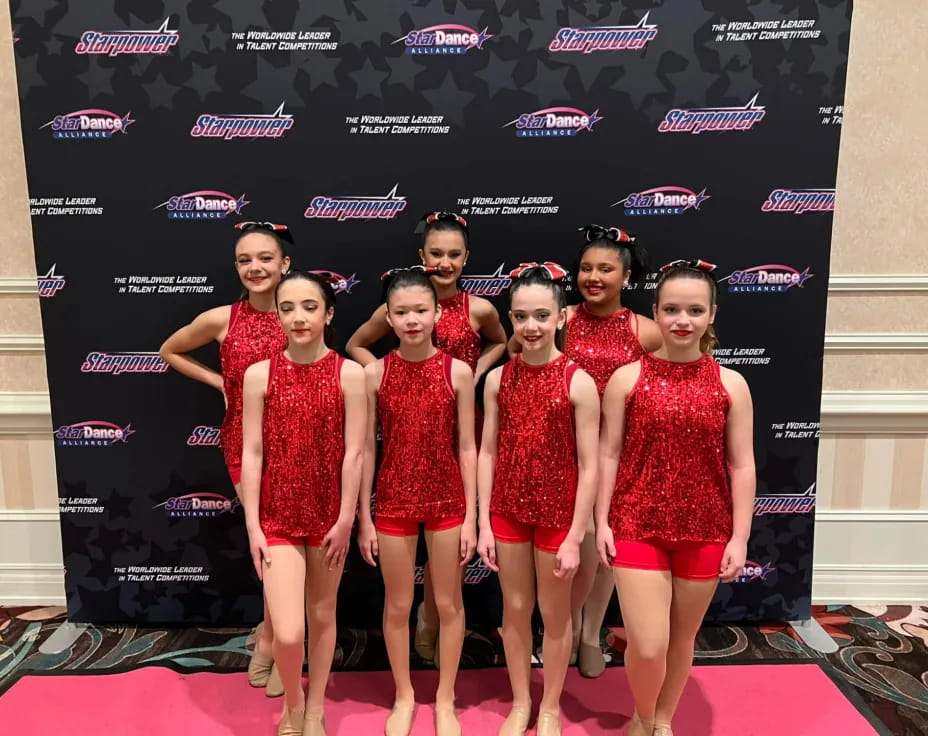 a group of women in red dresses