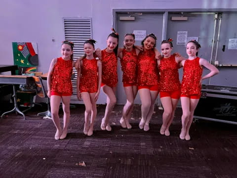 a group of women in red dresses