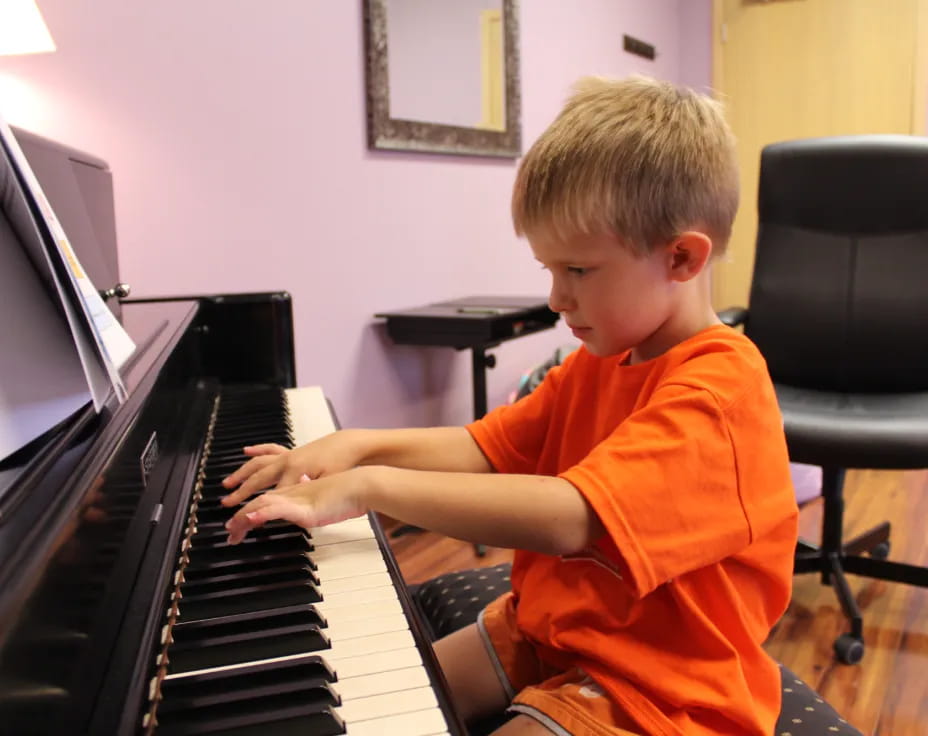 a boy playing a piano