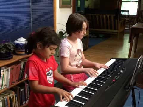 a couple of kids playing piano