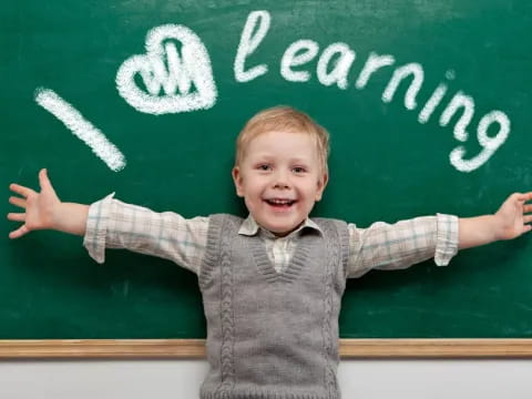 a boy standing in front of a chalkboard