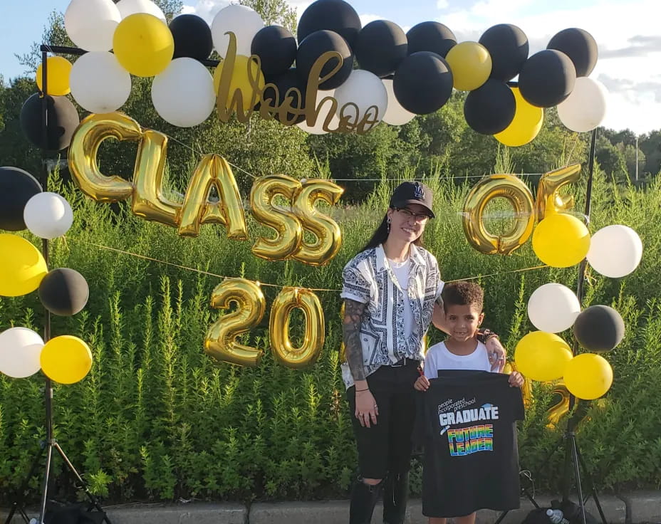 a man and a woman posing with a large group of balloons