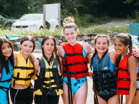 a group of girls wearing life vests