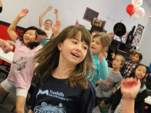 a group of children raising their hands