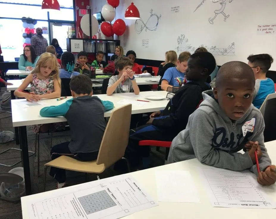 a group of children sitting at desks in a classroom