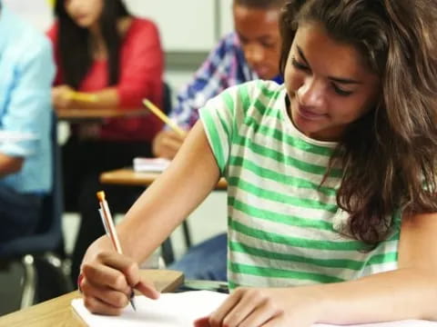 a young girl writing on a piece of paper