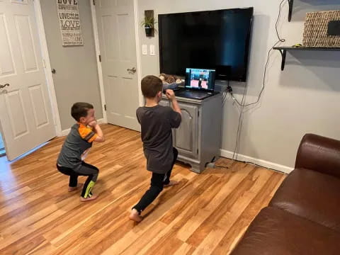 two boys playing with a laptop