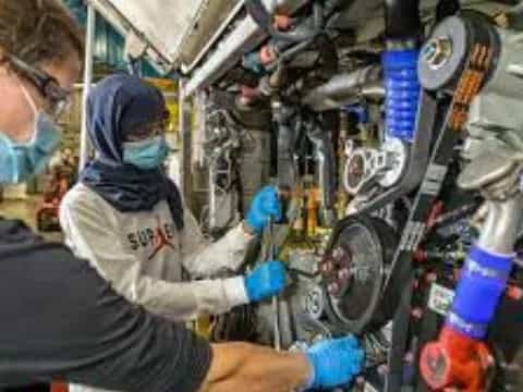 a man and a woman working on a car engine