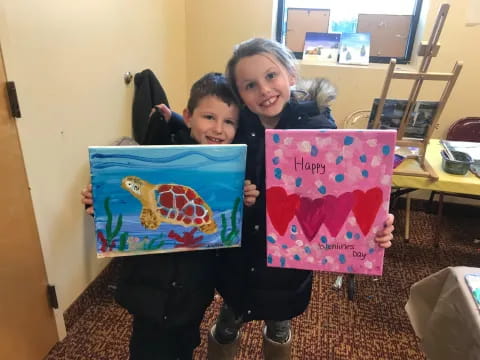 a couple of children holding up colorful paper